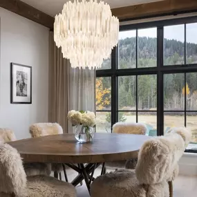 Enhance your dining space with custom layered drapery by GrandView Blinds & Designs. This rustic-modern dining room showcases elegant window treatments that provide versatile light control, privacy, and rich texture, complementing the interior design and scenic view.