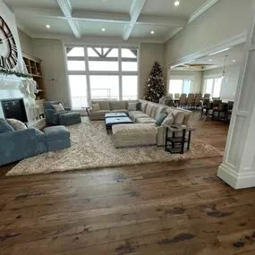 Unify your open-plan living space with consistent, custom cellular shades from GrandView Blinds & Designs. This view showcases light-filtering shades providing privacy and style across large windows, complementing the transitional decor and coffered ceiling.