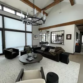 Achieve seamless style and light control in your modern rustic home with custom shades from GrandView Blinds & Designs. This great room features light-filtering window treatments perfectly complementing the vaulted ceilings, wood beams, and large windows.