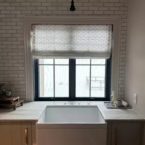 Add style and function above your sink with a custom Roman shade from GrandView Blinds & Designs. This patterned fabric shade provides light filtering and privacy, perfectly complementing the modern farmhouse aesthetic.