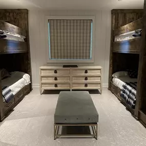 Add a touch of rustic charm and essential light control to bunk rooms with custom Roman shades from GrandView Blinds & Designs. This plaid fabric shade provides privacy and coordinates perfectly with the built-in wooden bunks.