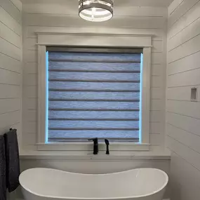Achieve modern style and adjustable privacy in your bathroom with custom banded (zebra) shades from GrandView Blinds & Designs. Perfect for over the tub, they allow easy transition between natural light and seclusion.