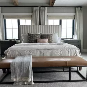 Achieve ultimate light control and style in your bedroom with layered window treatments from GrandView Blinds & Designs. This setup combines light-filtering Roman shades with elegant drapery panels for versatile options, from soft light to room darkening.