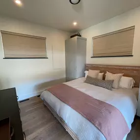 Ensure privacy and manage light in bedrooms with custom Roman shades from GrandView Blinds & Designs, ideal for high horizontal windows often found in modern rustic designs.