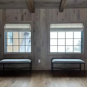 Complement natural wood interiors with custom Roman shades from GrandView Blinds & Designs. These faux linen cordless shades offer a clean look, light control, and enhanced safety, blending perfectly with modern rustic wood paneling and beams.