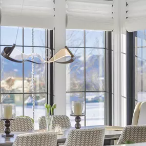 Enhance your dining experience with custom Roman shades from GrandView Blinds & Design. These elegant window treatments offer privacy and light control, beautifully framing your view.