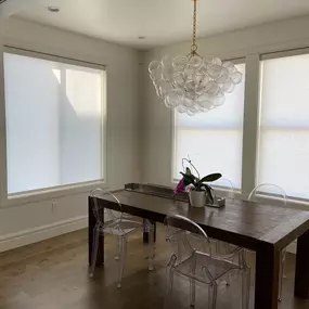 Complement your modern dining room with sleek roller shades from GrandView Blinds & Designs. This space showcases light-filtering shades providing glare reduction and soft, natural light while maintaining a clean, contemporary aesthetic.