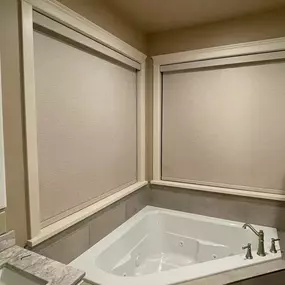Ensure privacy and manage moisture in your bathroom with durable and stylish roller shades from GrandView Blinds & Design. Custom-fit for areas like corner tubs, offering functionality and a clean look.