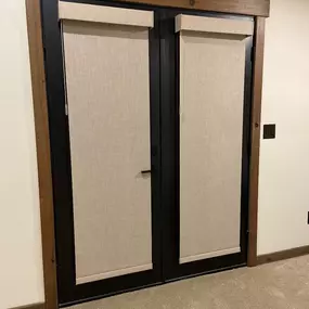Enhance your glass doors with stylish and functional roller shades from GrandView Blinds & Design. These custom window treatments provide privacy and light control, complementing design elements like wood trim.