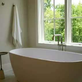 beautiful luxury master bathroom with a bathtub next to a large private window in a model home that can be built for the Peninsula at Wilson lake neighborhood lots for sale