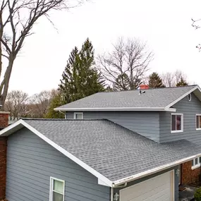 new asphalt shingle roof on blue house