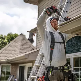 larson home services employee installing gutters