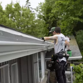two larson home services employees working on gutters