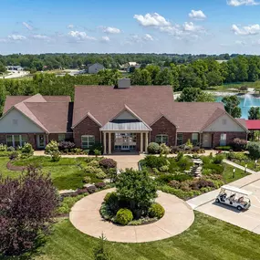 Exterior view of The Waterways of Lake Saint Louis' clubhouse, located close to a pond and well-maintained grounds.