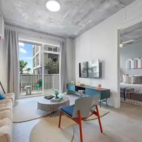 Bright and stylish living space with modern furnishings, industrial accents, and a private balcony.