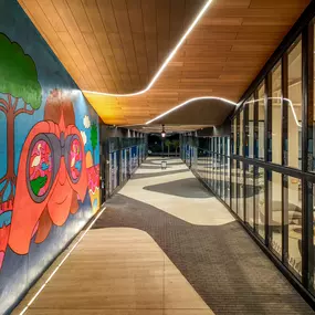 Vibrant pedestrian paseo featuring artistic murals, modern architecture, and dynamic lighting.