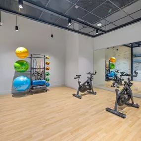 A vibrant fitness studio equipped with various exercise equipment like stationary bikes, fitness balls, and resistance bands.