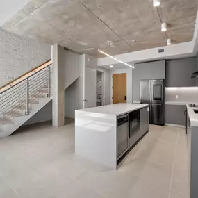 A modern, open-concept kitchen with sleek, gray cabinetry and a large kitchen island.
