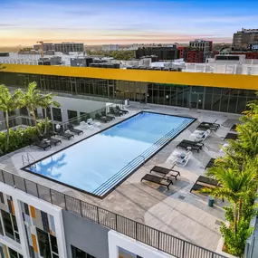 A stunning rooftop pool with a serene atmosphere, offering sunbathing chairs and a refreshing swim with a panoramic city view.