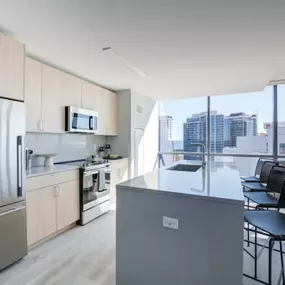 The kitchen at Encore Apartments combines sleek modern appliances with breathtaking city views.