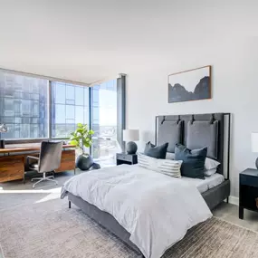 The master bedroom at Encore Apartments offers a spacious layout with sweeping city views.