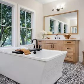 Spa-like primary baths featuring free-standing tub and dual sink vanities