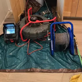 A setup of hydro jetting and camera inspection tools beneath a kitchen sink, prepared for unclogging services. Knight Rooter uses advanced technology to solve tough clogs in kitchen drains efficiently.