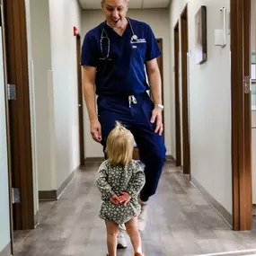 Dr. Wagner walking down the clinic hall talking to a very young patient