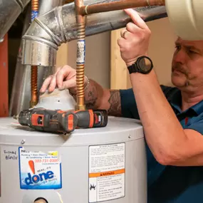 A Done plumber fixing a water heater in a home