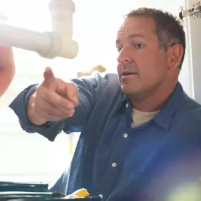 A plumber discussing issues with a homeowner about the kitchen sink plumbing