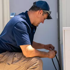 A B. Carlson Heating, Cooling & Plumbing, Inc. technician inspecting an HVAC unit