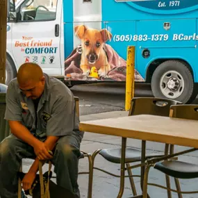 A B. Carlson Heating, Cooling & Plumbing, Inc. waiting in the dispatch office petting a dog