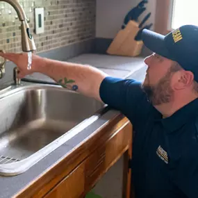 A Mainstream plumber fixing a kitchen sink