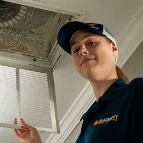 Radiant San Antonio employee cleaning an air duct