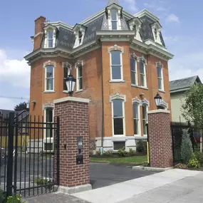 a red brick house with a black wrought iron gate at The Granite Works Apartments , Buffalo