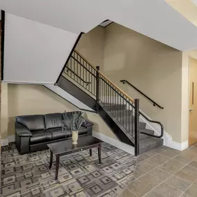 a living room with a couch and a staircase at The Granite Works Apartments , New York