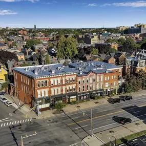 an aerial view of a building with a blue roof on a city street at The Granite Works Apartments , Buffalo
