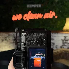 Kameraaufnahme von einer Szene mit dem Schriftzug 'we clean air' im Hintergrund, während eines Shootings bei Kemper