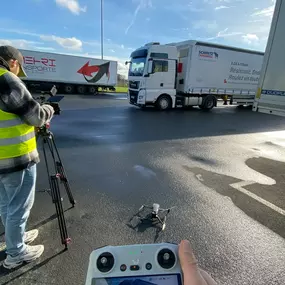 Drohnenaufnahme bei Welf Online: Vorbereitung für ein Videoprojekt auf einem Schmitz Cargobull Gelände mit LKWs im Hintergrund