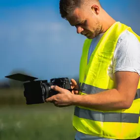 Videograf von Welf Online bei Außenaufnahmen mit Kamera in Sicherheitsweste