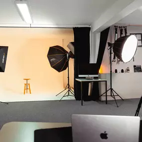 Fotostudio von Welf Online mit professionellem Beleuchtungs-Setup und Hocker vor einem hellen Hintergrund