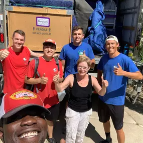 Movers and a happy customer posing for a group photo.