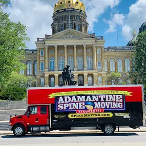 Adamantine Spine Moving truck parked in front of a capitol building.