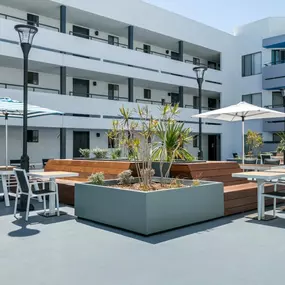 a patio with tables and chairs and umbrellas in front of a building