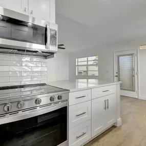 Wonderful condominium galley kitchen with quartz counter tops and custome wood shaker cabinets