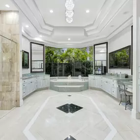 Beautiful master bathroom with custom cabinets and marble flooring and shower