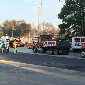 three pks paving trucks parked at a job site