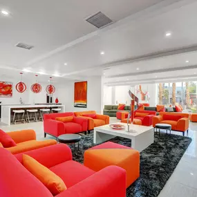 a living room with orange couches and chairs and a table