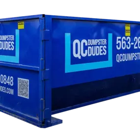 A close-up image of a blue QC Dumpster Dudes dumpster, featuring company branding, phone number, and website.