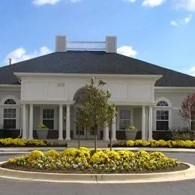 a large white house with yellow flowers in front of it